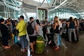 インドネシア・バリ島デンパサールのバリ（ヌグラライ）国際空港で、遅延便の情報を求めて並ぶ人々（2015年7月22日撮影）。(c)AFP/SONNY TUMBELAKA