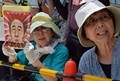都内・国会議事堂そばで行われた安倍政権への抗議デモで、プラカードを掲げスローガンを唱えるデモ参加者（2014年7月14日撮影）。(c)AFP/Yoshikazu TSUNO