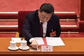 中国・北京の人民大会堂で開かれた全国人民代表大会（全人代）で、香港の選挙制度改革に関する議案の投票に臨む習近平国家主席（2021年3月11日撮影）。(c)NICOLAS ASFOURI / AFP