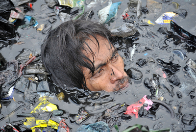 スラム火災、汚泥泳いで物品探す住民 フィリピン