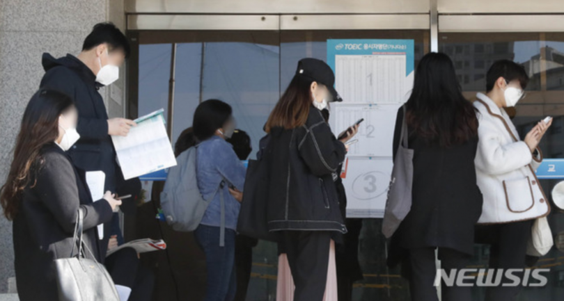 ソウル市内のTOEIC試験場の前でマスクを着用した受験者たちが待機している(c)NEWSIS