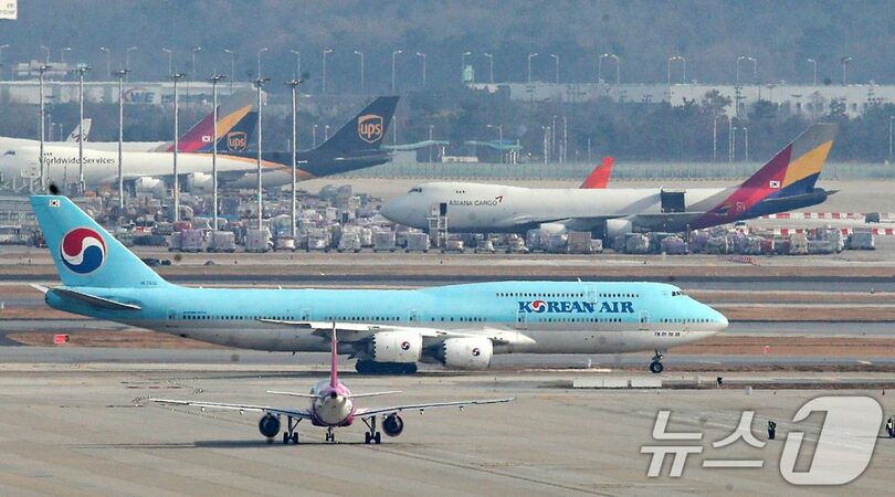 仁川空港の駐機場と滑走路に並ぶ大韓航空とアシアナ航空の航空機(c)news1
