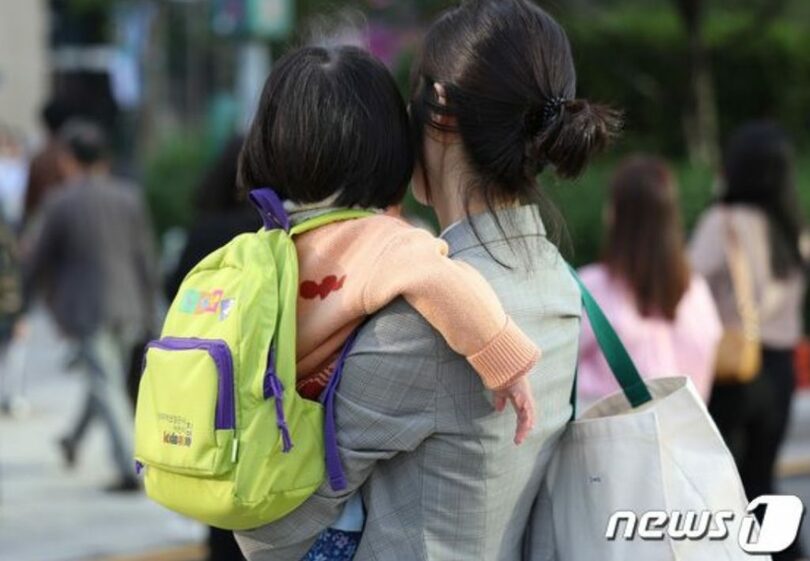 母親の胸に抱かれて登園する子ども(c)news1