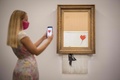 英覆面アーティスト、バンクシーの作品「Love is in the Bin」。ロンドンのサザビーズで（2021年9月3日撮影）。(c)Tolga Akmen / AFP
