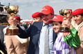 プリンスオブペンザンスで2015年のメルボルンカップを制し、トロフィーを手にポーズをとるミッシェル・ペイン騎手（中央右）とダレン・ウィアー調教師（中央、2015年11月3日撮影、資料写真）。(c)PAUL CROCK / AFP