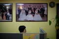 韓国・ソウル（Seoul）北郊の議政府（Uijeongbu）市にある結婚仲介業者のオフィスで、壁に飾られた国際結婚カップルの写真（2014年2月26日撮影）。(c)AFP/Ed Jones