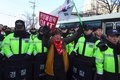 韓国・江陵での北朝鮮楽団の公演を前に、「平壌五輪はいらない」と書かれたカードを持って抗議デモを行う人（2018年2月8日撮影）。(c)AFP PHOTO / JUNG Yeon-Je