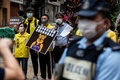 香港の警察署前で、中国の習近平国家主席を暗喩する「くまのプーさん」を描いたプラカードを手にする民主派の活動家ら（2020年5月24日撮影）。(c)AFP/ISAAC LAWRENCE