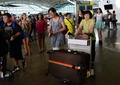 インドネシア・バリ島デンパサールのバリ（ヌグラライ）国際空港で、遅延便の情報を求めて並ぶ人々（2015年7月22日撮影）。(c)AFP/SONNY TUMBELAKA