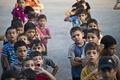 パレスチナ自治区ガザ（Gaza）地区の国連（UN）が運営する学校校庭に並ぶパレスチナ人の子どもたち。イスラム原理主義組織ハマス（Hamas）とイスラエルの戦闘によって家を失った数百家族が、現在この学校で避難生活を送っている（2014年8月24日撮影）。(c)AFP/ROBERTO SCHMIDT