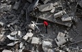 パレスチナ自治区ガザ地区（Gaza Strip）ガザ市（Gaza City）で、ミサイル着弾で倒壊した集合住宅のがれきの中に私物がないか調べる男性（2014年8月24日撮影）。(c)AFP/THOMAS COEX