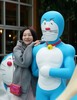 作品に登場するドラえもんの道具「うそつきかがみ」に映ったドラえもんと記念撮影する女性（2025年3月28日撮影）。(c)Xinhua News