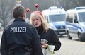 ドイツ北部ブラウンシュバイクで、「イスラム過激派による襲撃の具体的な脅威」をうけて中止となったカーニバル（謝肉祭）のパレード会場近くで警察官と話す参加予定者（2015年2月15日撮影）。(c)AFP/DPA /JULIAN STRATENSCHULTE