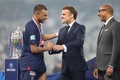 サッカーフランス杯決勝、オリンピック・リヨン対パリ・サンジェルマン。表彰式でフランスのエマニュエル・マクロン大統領（中央）から優勝を祝福されるパリ・サンジェルマンのキリアン・エムバペ（左、2024年5月25日撮影）。(c)Denis Charlet/ AFP