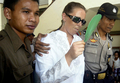 写真は30日、デンパサール地裁で入廷するCondon容疑者（中央）。(c)AFP/Sonny TUMBELAKA