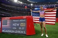 パリ五輪、陸上女子400メートルハードル決勝。世界新記録を示す電光掲示板の横で金メダル獲得を喜ぶ米国のシドニー・マクラフリンレブロニ（2024年8月8日撮影）。(c)Ben STANSALL / AFP