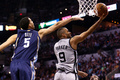 12-13NBA、ウェスタンカンファレンス決勝（7回戦制）第1戦、サンアントニオ・スパーズ（San Antonio Spurs）対メンフィス・グリズリーズ（Memphis Grizzlies）。ディフェンスをかわしてシュートを狙うサンアントニオ・スパーズのトニー・パーカー（Tony Parker、右、2013年5月19日撮影）。(c)AFP/Getty Images/Ronald Martinez