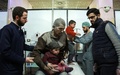 シリアの首都ダマスカス近郊の反体制派支配地区、東グータで、政権軍によるとみられる空爆後、子どもと仮設の診療所を訪れた粉塵まみれの男性（中央、2018年2月24日撮影）。(c)AFP PHOTO / HAMZA AL-AJWEH