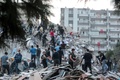 トルコのイズミルで、地震により倒壊した建物で行方不明者の捜索を行う人々（2020年10月30日撮影）。(c)MERT CAKIR / AFP