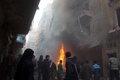 シリア北部アレッポ（Aleppo）の反体制派が掌握する地区で、空爆による被害状況を確かめる住民（2013年12月15日撮影）。(c)AFP/MOHAMMED AL-KHATIEB