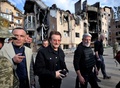 ウクライナの首都キーウ近郊イルピンの住宅地を訪れたロックバンド「U2」のボノさん（中央、2022年5月8日撮影）。(c)Genya SAVILOV / AFP