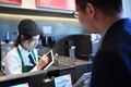 南京市にオープンしたスターバックスの手話店舗で筆談ボードを使って来店者と交流する聴覚障害のある店員（2023年11月28日撮影）。(c)Xinhua News