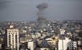 パレスチナ自治区ガザ地区（Gaza Strip）ガザ市（Gaza City）で、イスラエル軍の空爆を受けた建物から立ち上る黒煙（2014年7月12日撮影）。(c)AFP/MAHMUD HAMS