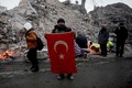 トルコ・カフラマンマラシュの地震被災地で国旗を手にする人（2023年2月12日撮影）。(c)OZAN KOSE / AFP