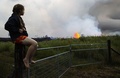 米ハワイにあるハワイ島のキラウェア火山の亀裂から流れ出る溶岩を見つめる住民。同島のカポホにて（2018年5月19日撮影）。(c)Mario Tama/Getty Images/AFP