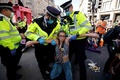 英ロンドン中心部オックスフォードサーカスで、「絶滅への反逆」メンバーを排除する警察官（2021年8月25日撮影）。(c)Tolga Akmen / AFP