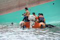 フィリピン中部ロンブロン（Romblon）州シブヤン島（Sibuyan Island）沖で転覆した大型フェリー「プリンセス・オブ・ザ・スターズ（Princess of the Stars）」の船体と、船内から遺体を回収したフィリピン沿岸警備隊の潜水救助チーム（2008年6月23日撮影）。(c)AFP/ROMEO GACAD