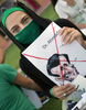 ドバイ（Dubai）のイスラム・アザド大学（Islamic Azad University）前でイラン大統領選挙に抗議する座り込みに参加したイラン人ら。イラン大統領選で再選されたマフムード・アフマディネジャド（Mahmoud Ahmadinejad）大統領の風刺画を掲げている（2009年6月16日撮影）。(c)AFP/MARWAN NAAMANI