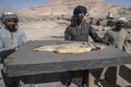 エジプト・ルクソール近郊で発見された古代都市遺構で、出土した魚の化石を運ぶ作業員（2021年4月10日撮影）。(c)Khaled DESOUKI / AFP