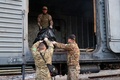 ウクライナ東部ハルキウ州シニハ村で、ロシア兵の遺体を貨車に乗せるウクライナの部隊（2023年4月8日撮影）。(c)Sergiy KOZLOV / AFP