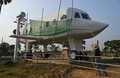 カンボジア・シエムレアプ近郊で、飛行機そっくりの自身の家を洗うチラチ・ポーさん（2023年3月12日撮影）。(c)TANG CHHIN SOTHY / AFP