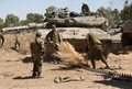イスラエルのパレスチナ自治区ガザ地区（Gaza Strip）との境界近くで、戦車を整備する兵士ら（2014年8月20日撮影）。(c)AFP/MENAHEM KAHANA