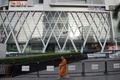 タイの首都バンコクにあるショッピングモール「セントラル・ワールド」の前を歩く僧侶（2015年9月9日撮影、資料写真）。(c)NICOLAS ASFOURI / AFP