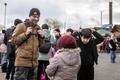 ポーランド東部メディカの国境検問所で、ウクライナから徒歩で避難してきたアフガニスタン人のアジュマル・ラフマニさんと子どもたち（2022年2月27日撮影）。(c)Wojtek RADWANSKI / AFP