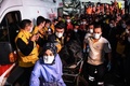トルコ・イズミルで、犠牲者を運ぶ医療従事者ら（2020年10月30日撮影）。(c)OZAN KOSE / AFP