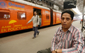 インド、ムンバイ（Mumbai）のチャーチゲート（Churchgate）駅のホームに座るSamir Zaveriさん。18歳の時に線路を歩いて渡ろうとして両足を失った。（2008年5月31日撮影）。(c)AFP/Sajjad HUSSAIN
