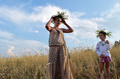 伝統的なスラブ民族の祭り「イワン・クパーラ（Ivan Kupala）の夜」が6日、東欧各地で行われた。起源をキリスト教以前にまでさかのぼるというこの祭りでは、人々が花輪を編んだり、たき火を飛び越えたり、裸で泳いだりして祝う。

写真はウクライナの首都キエフ（Kiev）近郊で、草の冠をかぶった母娘（2013年7月6日撮影）。(c)AFP/SERGEI SUPINSKY