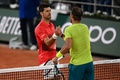 全仏オープンテニス、男子シングルス準々決勝。試合を終え、握手を交わすノバク・ジョコビッチ（奥）とラファエル・ナダル（2022年6月1日撮影）。(c)Christophe ARCHAMBAULT/ AFP