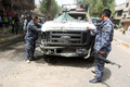 イラクの首都バグダッド（Baghdad）で起きた自動車爆弾攻撃の現場で、損傷した車を調べる警察官（2013年5月30日撮影）。(c)AFP/AHMAD AL-RUBAYE