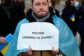仏西部レンヌで行われたロシアのウクライナ侵攻に抗議するデモで、「プーチン、戦争犯罪人！」と書かれた紙を持つ男性（2022年2月24日撮影、資料写真）。(c) DAMIEN MEYER / AFP
