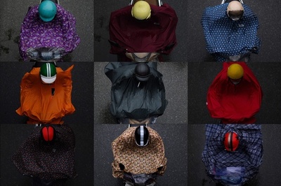 カラフルな雨がっぱのバイカーたち、雨模様のハノイがにぎやかに ベトナム