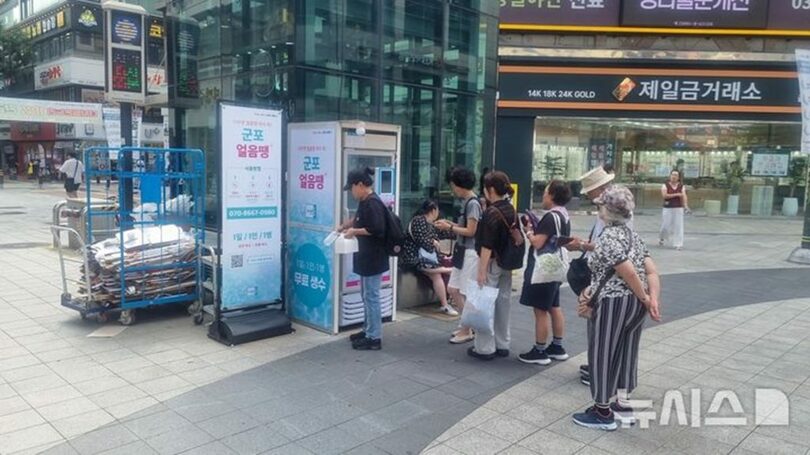 軍浦市中央公園に設置された「軍浦アイスドン」で冷たいミネラルウォーターを受け取るために列を作る市民ら＝軍浦市提供(c)NEWSIS