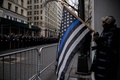 ウィルバート・モラ巡査の葬儀に警察官が集まる中、「Blue Lives Matter（警察官の命は大切）」の意味を表す旗を持つ人。米ニューヨークで（2022年2月2日撮影）。(c)Ed JONES/AFP