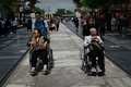 中国・北京で、車いすを押す人々（2021年5月11日撮影）。(c)WANG Zhao / AFP