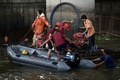 タイの首都バンコク中心部の高架鉄道BTSのサパーンタクシン駅近くで発生した爆発事件の捜査のため、ポンプを使って現場近くの運河から水を抜く当局者ら（2015年8月18日撮影）。(c)AFP/Christophe ARCHAMBAULT