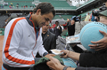 全仏オープンテニス2009（%%French Open 2009%%）男子シングルス決勝。大会第2シードのロジャー・フェデラー（%%Roger Federer%%、スイス）は、大会第23シードのロビン・ソデルリング（%%Robin Soderling%%、スウェーデン）と対戦。フェデラーは6-1、7-6、6-4で全仏初優勝を果たし、ピート・サンプラス（%%Pete Sampras%%、米国）氏の持つグランドスラム最多優勝記録（14勝）に並ぶと同時に、史上6人目の生涯グランドスラム（4大大会全制覇）を達成した。写真は試合後にファンへのサインに応じるロジャー・フェデラー（左）。（2009年6月7日撮影）(c)AFP/BERTRAND GUAY